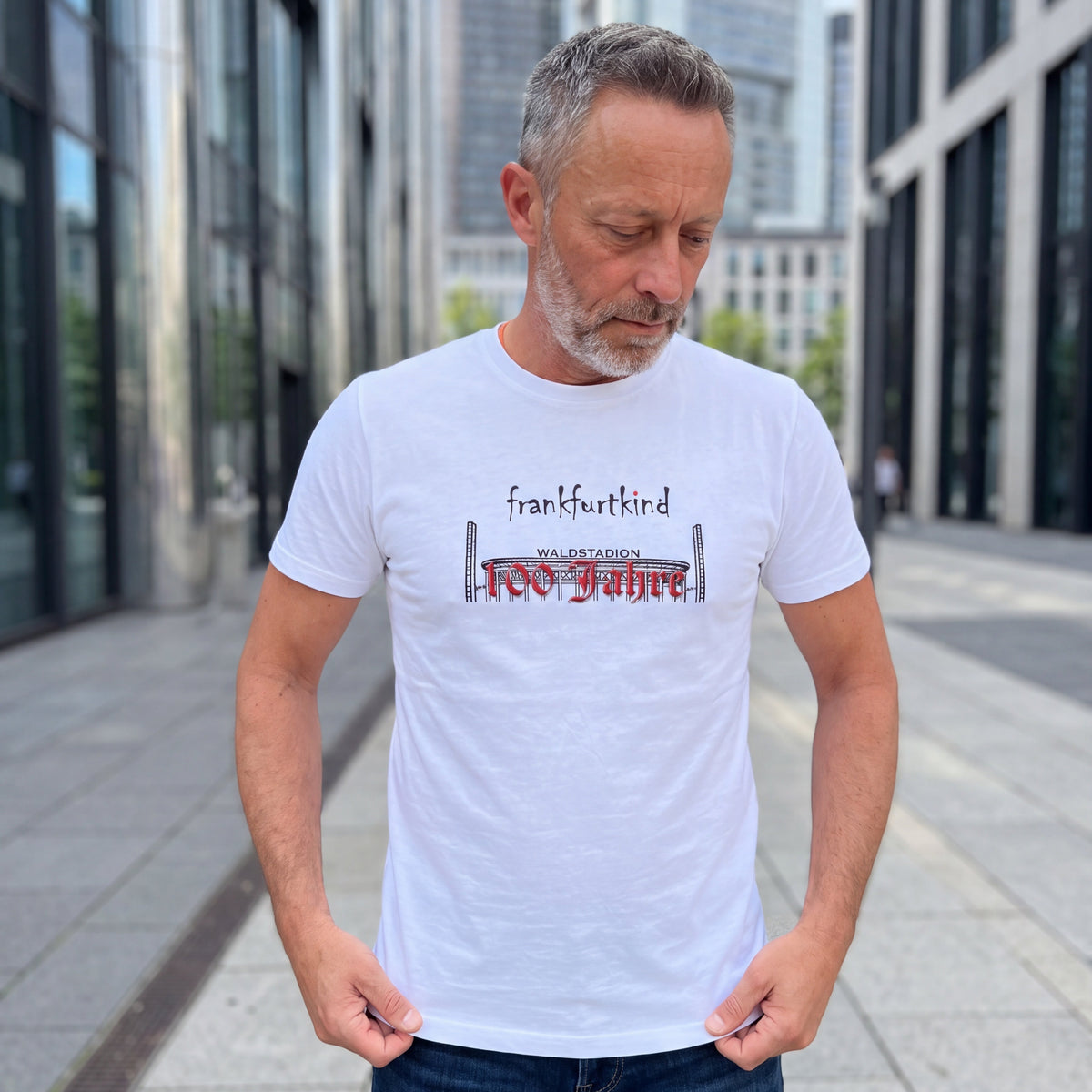 Weißes 100 Jahre Waldstadion Frankfurt T-Shirt von frankfurtkind mit Frontprint, getragen von einem männlichen Model.
