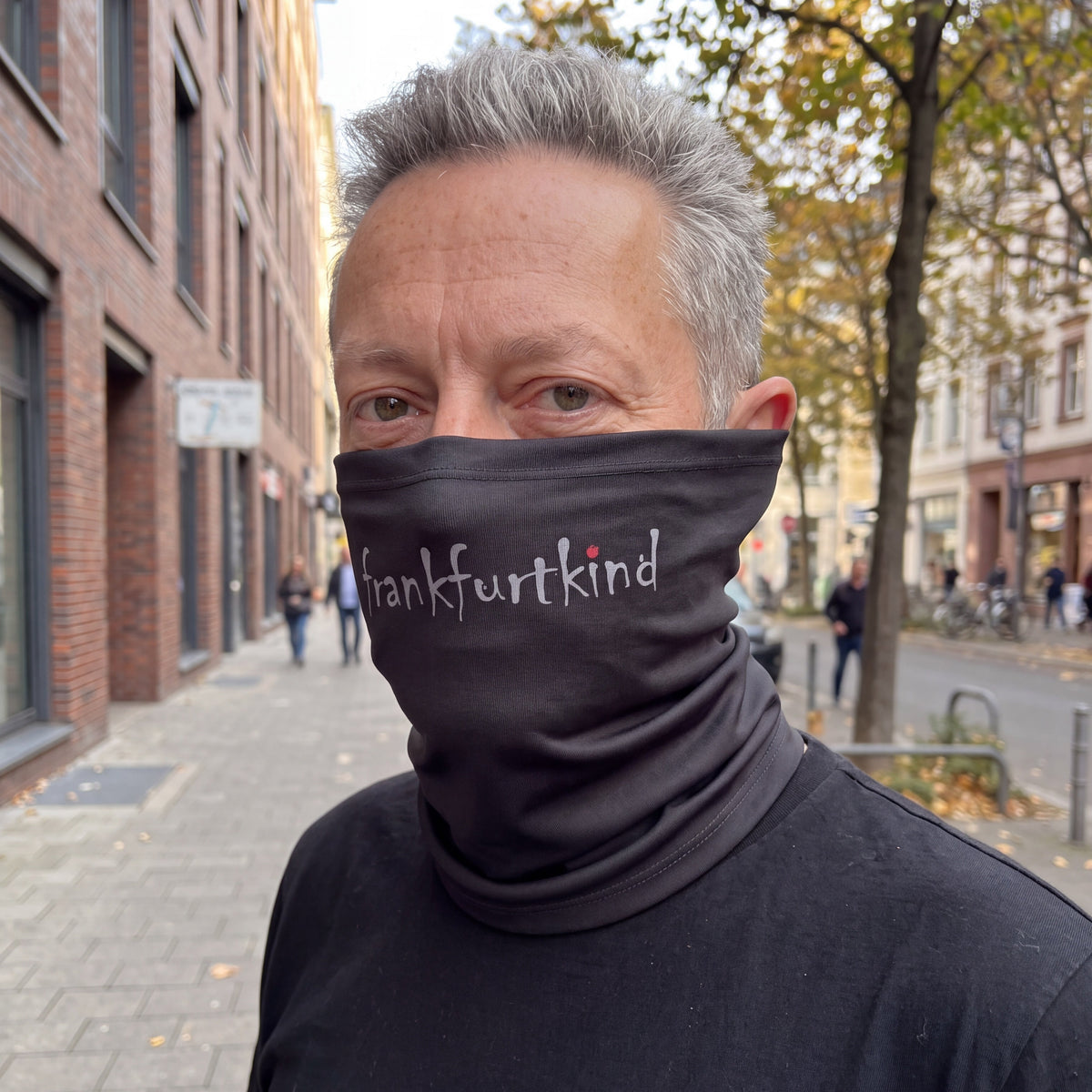 Schwarzer Schlauchschal mit frankfurtkind Print von einem männlichen Model getragen.