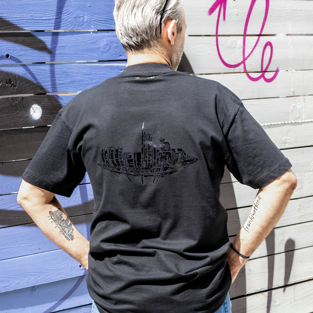 Schwarzes Skyline Black Frankfurt Heavy Oversized T-Shirt von frankfurtkind mit Rückenprint, getragen von einem männlichen Model.
