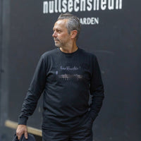 Schwarzes Waldstadion Black-Carbone Frankfurt Longsleeve von frankfurtkind mit Frontprint, getragen von einem männlichen Model.