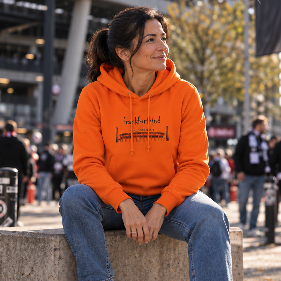 Orange Farbener Waldstadion Frankfurt Organic Hoodie von frankfurtkind mit Frontprint, getragen von einem weiblichen Model.